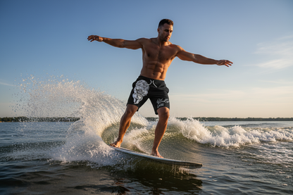Man wearing Shibari Trunks wake surfing behind a boat on a lake